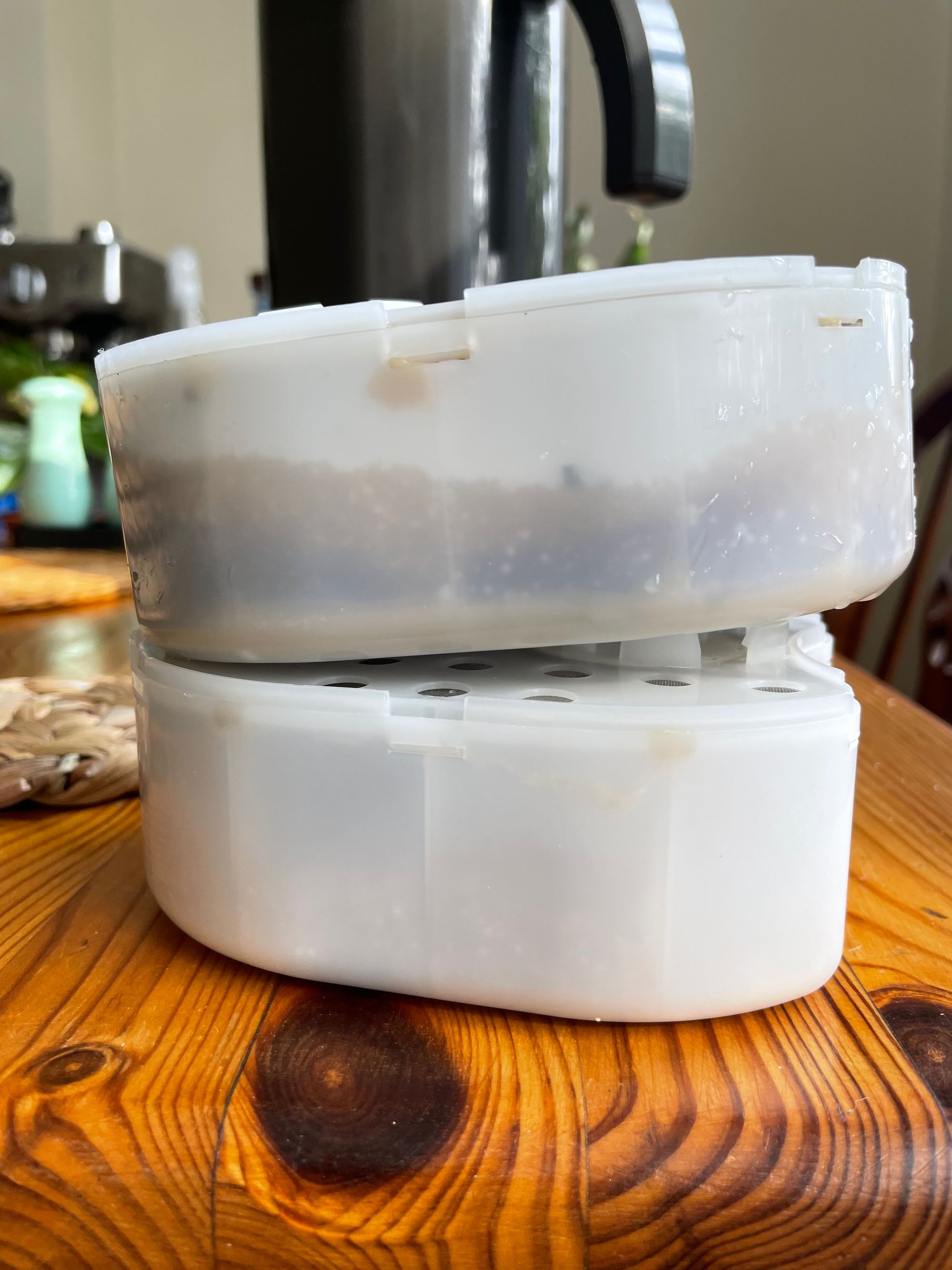 A used Peak Water filter on top of a fresh filter, showing the silt and minerals filtered out of the water.